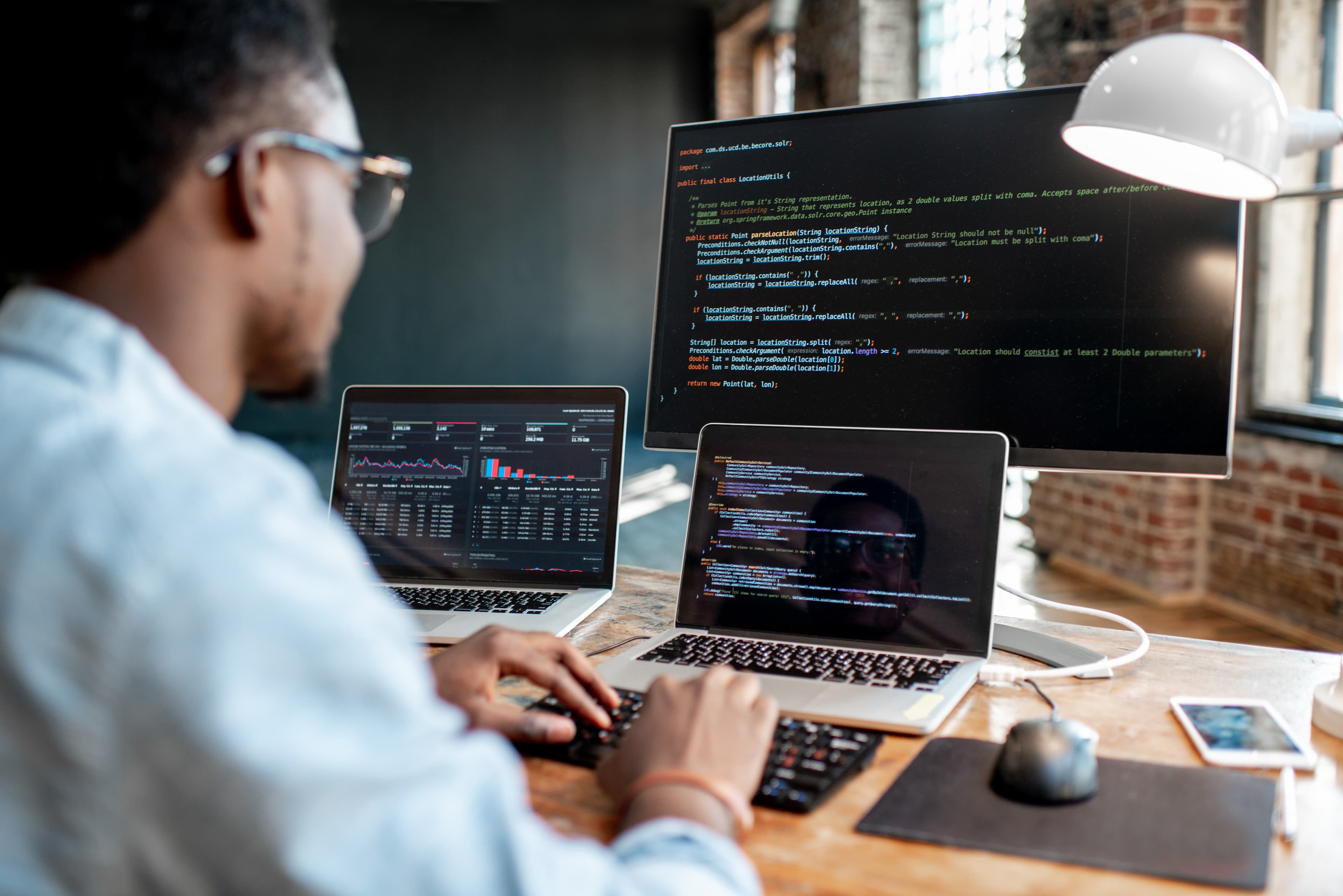 a man with three screens at desk